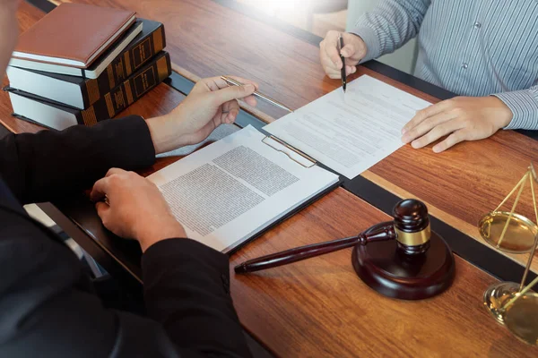 Müvekkille çalışan avukat, mahkeme salonundaki yasal mevzuat ile ilgili sözleşme belgelerini tartışıyor, müşterilerine danışmanlık yapıyor.