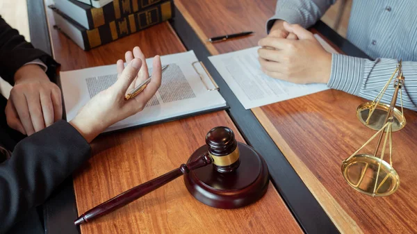 Lawyer working with client discussing contract papers with brass scale about legal legislation in courtroom, consulting to help their customer