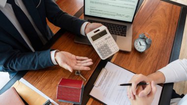 Emlak komisyoncusu ya da satış temsilcisi, ev sözleşmesi sözleşmesi sözleşmesi için müşteriye danışmanlık yapıyor. Ev kredisi kavramı