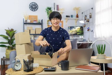 Küçük işletme kurun Asyalı genç girişimci paket paketleme karton kutu teslimat işlemi için ana ofis, çevrimiçi pazarlama müşteri göndermek için