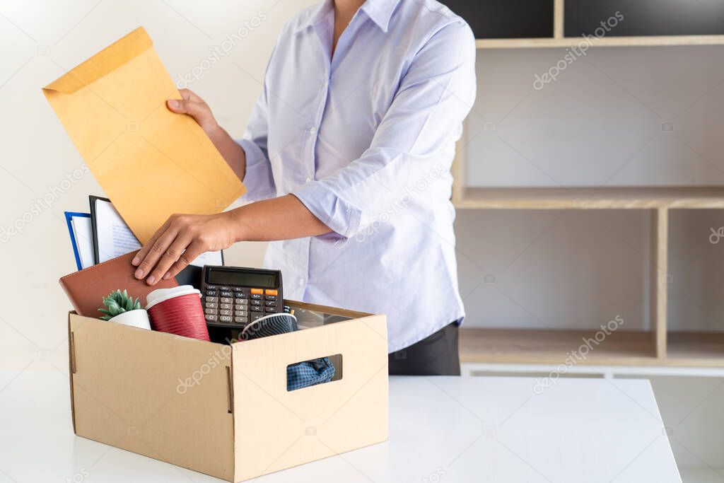 Businesswoman resigning from her job hold boxes and packing personal company for personal belongings. deciding resignation concept and changing work in future
