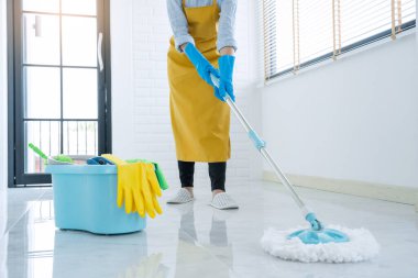 Genç temizlikçi ya da temizlik yeri koruyucu eldivenlerle paspas, Temizlik Servisi