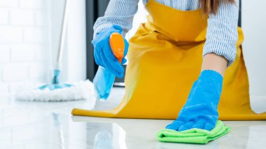 Temizlikçi, lastik eldiven giyip, kumaş temizliği yapıyor ya da evde, ev işi ve temizlik konseptini uyguluyor. 