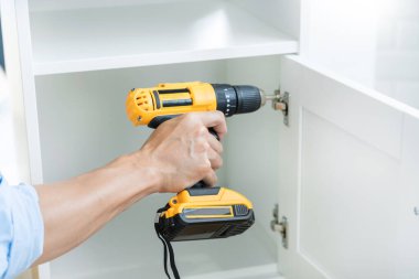 Elinde kablosuz tornavida tutan adamı kapat ve evde mobilya montajı yaparken vida vidaları yalan söylüyor.