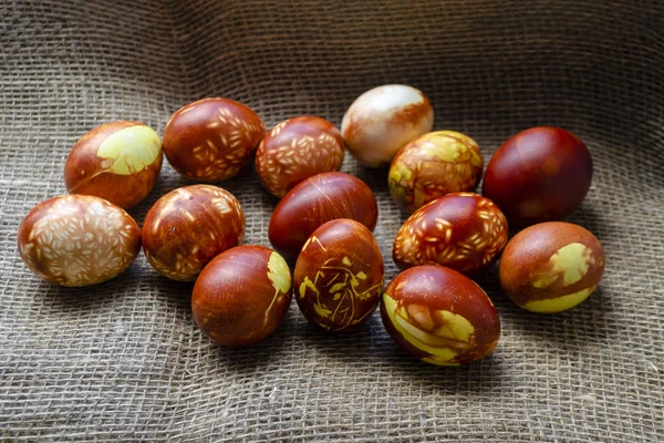 Huevos de pollo coloreados con método natural anticuado por cáscaras de cebolla. Huevos marrones con diferentes patrones naturales en la arpillera beige. Enfoque selectivo con copyspace. Concepto tradicional de Pascua y Primavera Imágenes De Stock Sin Royalties Gratis