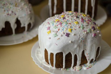 Geleneksel lezzetli Paskalya ekmeği, beyaz jöleli ve renkli şeker tozuyla tabakta. Geleneksel Ortodoks Noel kahvaltısı kavramı. Rus, Ukrayna Geleneksel Kuliç.