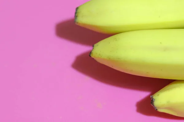 Επίπεδη lay αρκετές κίτρινες μπανάνες σε ένα ροζ φόντο πάνω άποψη. Αντιγραφή χώρου για κείμενο — Φωτογραφία Αρχείου