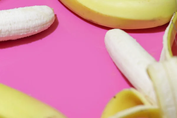 Kilka bananów z bliska widok z góry na różowym tle z miejsca na tekst. Układy płaskie — Zdjęcie stockowe