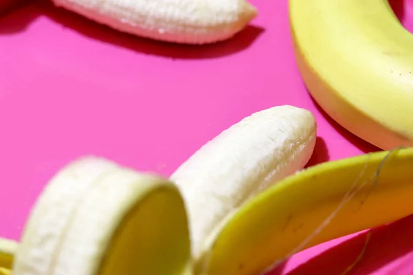 Αρκετές ανοιγμένες μπανάνες κλείνουν την επάνω όψη σε ροζ φόντο. Τροπικά — Φωτογραφία Αρχείου