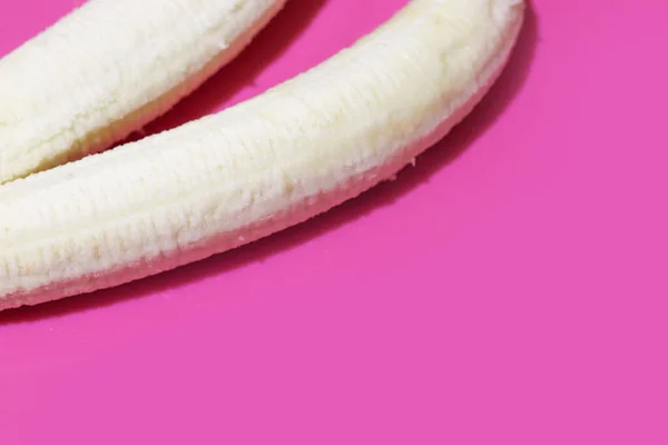 Dwa obrane banany na różowym tle, aby zobaczyć zbliżenie. Leżał płasko z przestrzenią kopiującą. Tropikalny banan dla zdrowego stylu życia — Zdjęcie stockowe