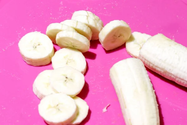Banana slices top view on bright pink background. Healthy eating and healthy lifestyle — Stock Photo, Image