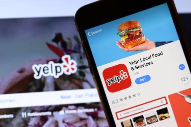 Ekranda Yelp simgesi olan cep telefonu dizüstü bilgisayardaki web sitesini kapat. Arka planda Yelp logosu var. Los Angeles, California, Usa - 9 Kasım 2019, Illustrative Editorial
