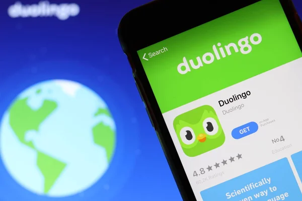 Ekranda Duolingo simgesi olan cep telefonu dizüstü bilgisayardaki web sitesini kapat. Duolingo logolu bulanık bir arkaplan. Los Angeles, California, Usa - 9 Kasım 2019, Illustrative Editorial