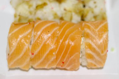 Philadelphia usulü suşi ve yılan balığının yan görüntüsü. Arka plan bulanık. Bir Japon restoranından suşi teslimatı. Boşluğu kopyala