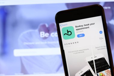 Ekranda Booksy simgesi olan telefon laptopta bulanık web sitesini kapat. Los Angeles, California, Usa - 30 Kasım 2019, Illustrative Editorial