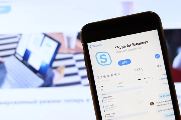 Skype for Businessのアイコンが画面上に表示されている電話は、ラップトップ上のぼやけたウェブサイトで閉じます。ロサンゼルス,カリフォルニア,アメリカ- 2019年11月30日,イラスト編集 — ストック写真