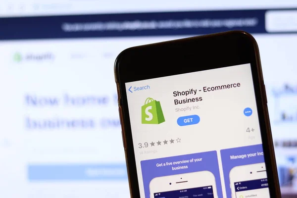 Телефон з іконою Shopify на екрані закритий з розмитим веб-сайтом на ноутбуці. Los Angeles, California, Usa - 30 November 2019, Illustrative Editorial — стокове фото