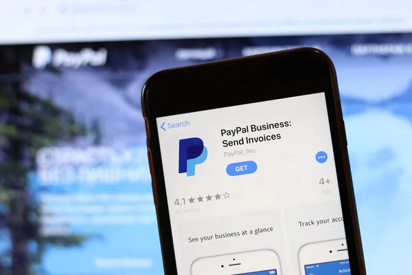 Телефон з іконою Paypal Business на екрані закритий з розмитим веб-сайтом на ноутбуці. Los Angeles, California, Usa - 30 November 2019, Illustrative Editorial — стокове фото