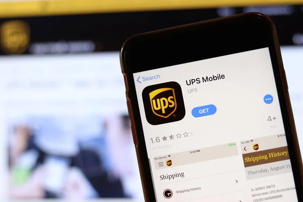 Телефон с иконкой UPS Mobile на экране крупным планом с размытым сайтом на ноутбуке. Лос-Анджелес, штат Калифорния, США - 30 ноября 2019 года — стоковое фото