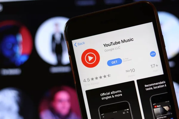 Telefone com ícone de música do YouTube na tela fechar com o site borrão no laptop. Los Angeles, Califórnia, EUA - 30 de novembro de 2019, Editorial Ilustrativo — Fotografia de Stock