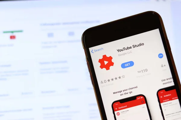 Phone with YouTube Studio icon on screen close up with blur website on laptop. Los Angeles, California, USA - 30 November 2019, Illustrative Editorial — Stock Photo, Image