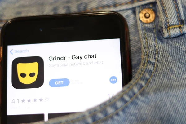 Телефон с иконкой приложения Grindr на экране в синих джинсах крупным планом. Лос-Анджелес, штат Калифорния, США - 30 ноября 2019 года — стоковое фото