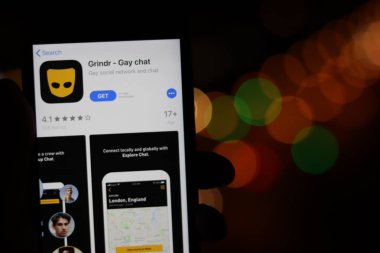Grindr uygulama simgesiyle telefon ekranda bulanık arkaplanlı. Los Angeles, California, Usa - 30 Kasım 2019, Illustrative Editorial