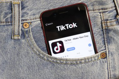 Los Angeles, California, Usa - 5 Aralık 2019: Tiktok uygulama simgesi telefon ekranında kot pantolonun cebinde. Açık kot arka planlı İphone 'daki Uygulama Mağazası logosu, Resimli Editör