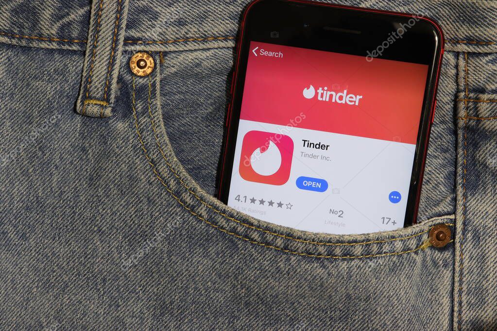 Los Angeles, California, USA - 5 December 2019: Tinder app icon on phone screen in blue jeans pocket. App Store logo on Iphone with light denim Background, Illustrative Editorial.