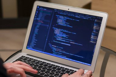 Laptop üzerinde çalışan bir uzman. Eller klavyede. Programcı yazma kodu