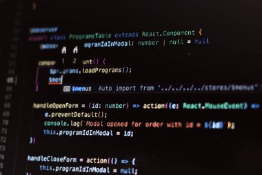 Gerçek program kodu yakın plan. Bir dizüstü bilgisayarın koyu arkaplanındaki kod satırları