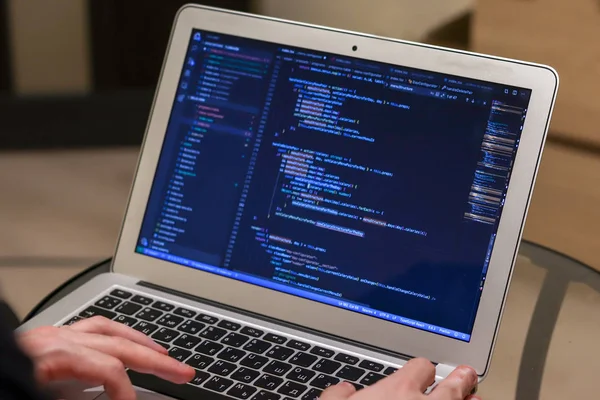 IT specialist working on laptop. Hands on keyboard. Programmer writing code