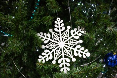 Kış oyuncağı kar tanesi bir Noel ağacına yakın duruyor. Noel arkaplanı. Tatil kavramı