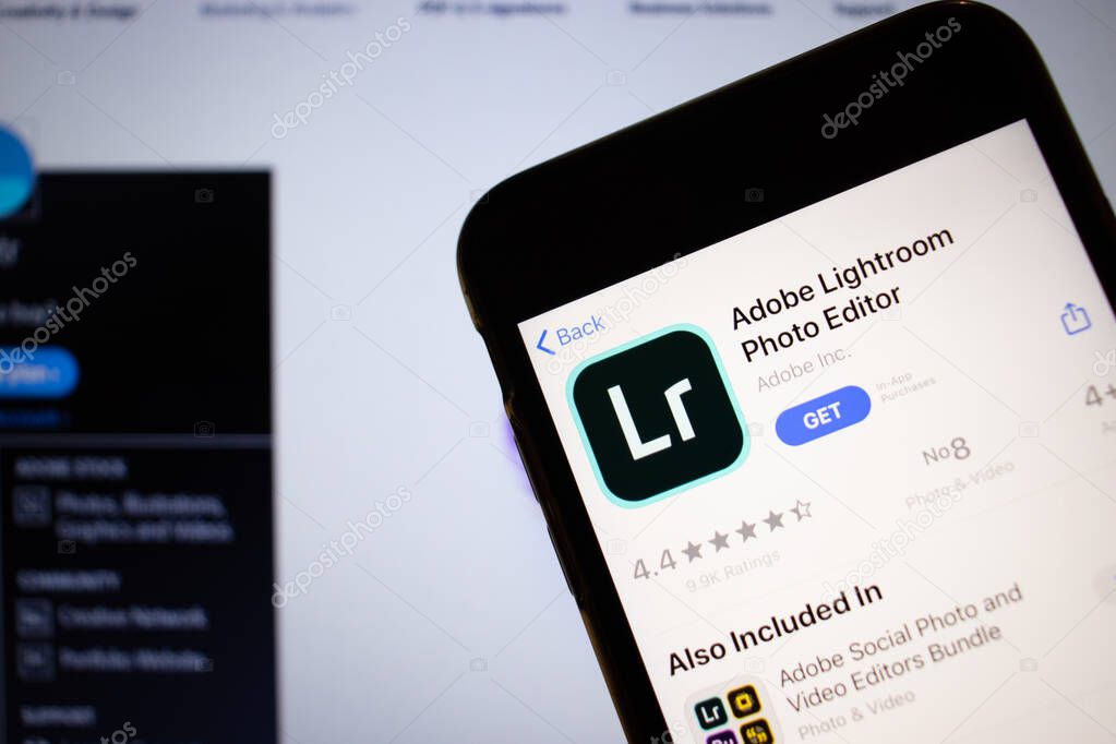 Saint-Petersburg, Russia - 10 January 2020: Mobile phone with Adobe Lightroom Photo Editor icon on screen close up with website on laptop, Illustrative Editorial.