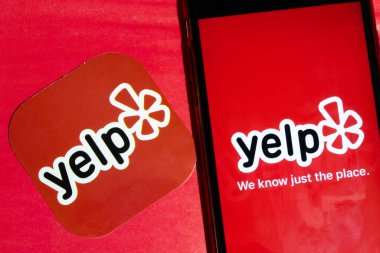 Los Angeles, California, USA - 22 January 2020: yelp app logo and phone with icon close up on red background, Illustrative Editorial clipart