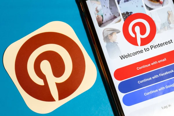 Los Angeles, California, USA - 22 January 2020: Pinterest app logo and phone with icon close up on blue background, Illustrative Editorial — Stock Photo, Image