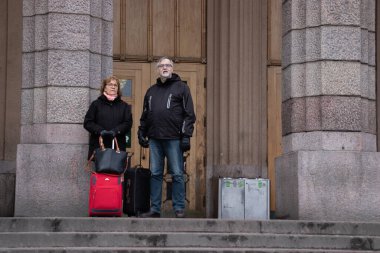 Helsinki, Finlandiya - 3 Mart 2020: Rautatieasema Jarnvags İstasyonu 'nun girişine yakın duran turistler.