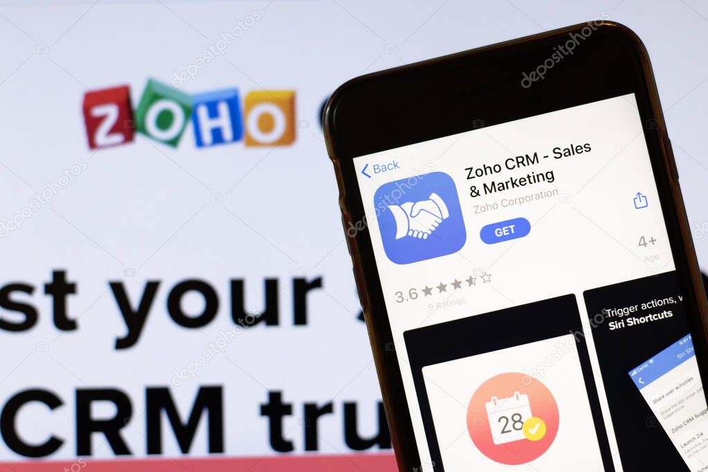 Los Angeles, California, USA - 24 March 2020: Zoho CRM app logo on phone screen close up with website on background with icon, Illustrative Editorial.