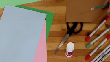 Aile yaratıcılığı sürecinde, bir erkek ve bir kız kardeş kağıt üzerine çizer ve yaratıcı çocukların el yapımı oyuncakları için malzemeler hazırlarlar. Sanat atölyesi konsept görüntü üst görünüm