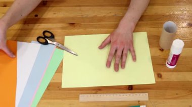 Tasarımcı masada kağıtlarla çalışır. Üst görünüm