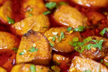 Dum Aloo - patatesli Hint vejetaryen yemeği, domates soğanında yavaş pişirilmiş, kırmızı biberli sos. Dümdüz yakın çekim. Hint mutfağı ve Bengali bölgesel yemekleri..