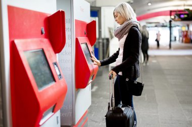 Tren bileti satış makinesi istasyonda kullanarak satın alma kadın