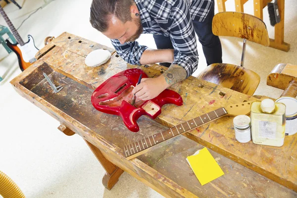 Rzemieślnik pracuje w warsztacie z gitarą — Zdjęcie stockowe