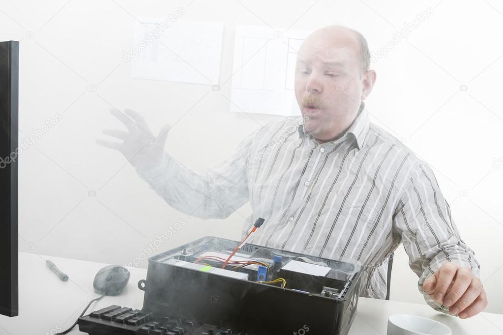 Businessman Blowing Smoke Emerging From Computer Chassis