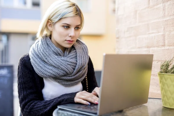 Ung fokuserad kvinna som arbetar på Laptop på utomhus Cafe — Stockfoto