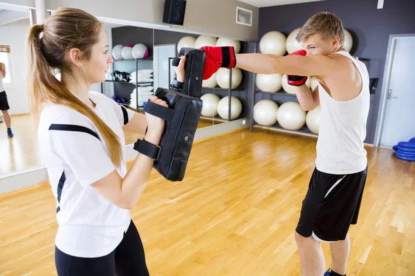 Worek treningowy bokser w posiadaniu instruktor kobiece — Zdjęcie stockowe