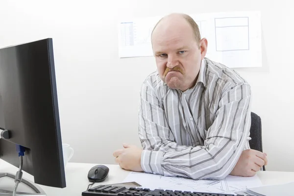 Wütender reifer Geschäftsmann sitzt am Schreibtisch — Stockfoto