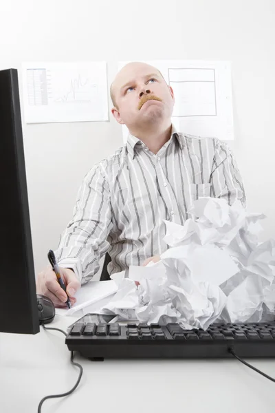 Geschäftsmann schreibt mit abgewiesenen Papieren auf Tastatur — Stockfoto