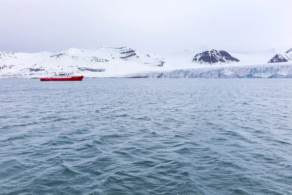 Barca di spedizione di fronte a un ghiacciaio massiccio — Foto Stock
