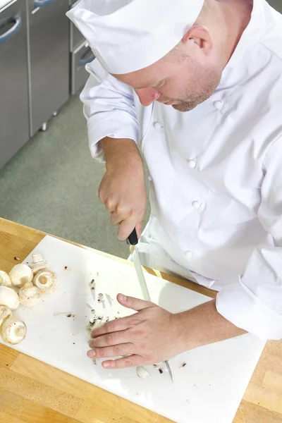 Professionell kock förbereder svampar i stort kök — Stockfoto